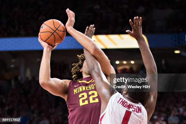 Trey Thompson of the Arkansas Razorbacks gets tangled up with Reggie Lynch of the Minnesota Golden Gophers at Bud Walton Arena on December 9, 2017 in...