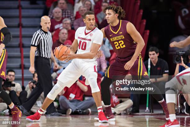 Daniel Gafford of the Arkansas Razorbacks has the ball under the basket against Reggie Lynch of the Minnesota Golden Gophers at Bud Walton Arena on...