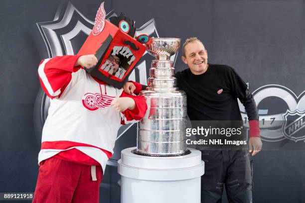 Darren McCarty and a fan pose for a photo with the Stanley Cup during the NHL Centennial Fan Arena on December 3, 2017 in Detroit, Michigan.