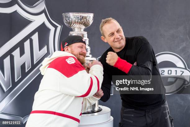 Darren McCarty and a fan pose for a photo with the Stanley Cup during the NHL Centennial Fan Arena on December 3, 2017 in Detroit, Michigan.