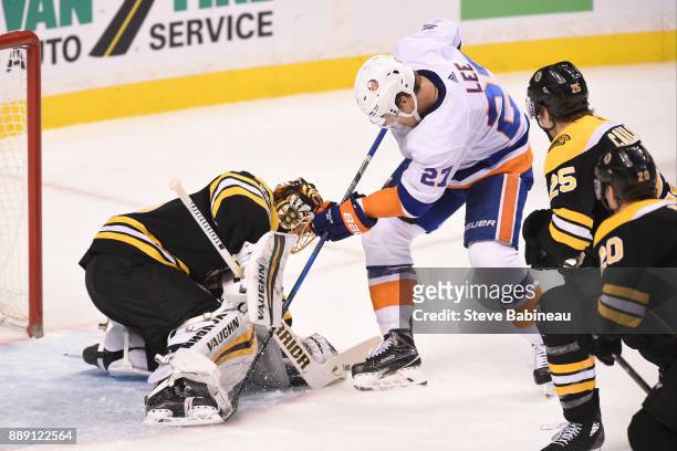 Anders Lee of the New York Islanders fight for the loose puck against Tuukka Rask of the Boston Bruins at the TD Garden on December 9, 2017 in...
