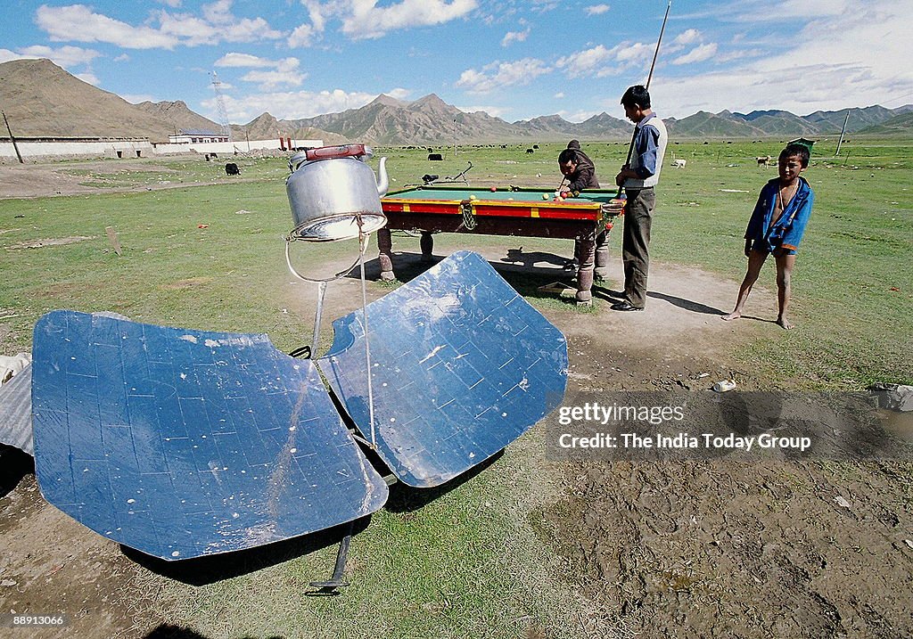 Villagers playing pingpong in a Central Tibet village near Lhatse. Food gets cooked in a Solar cooker. Ping-pong is a Chinese game somewhat similar to snooker. (Kailash Mansarovar Yatra)