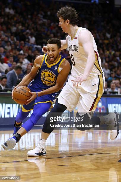 Stephen Curry of the Golden State Warriors drives against Omer Asik of the New Orleans Pelicans during the second half of a game at the Smoothie King...