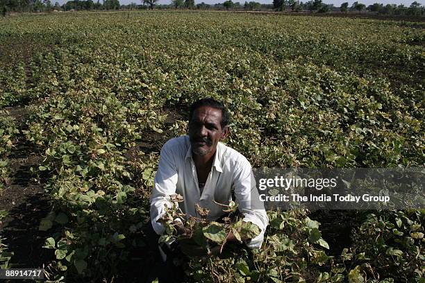 Farmer Gokul Prasad with a dry crop sitting at his agricultural land and looking for monsoon cloud in Bhopal, Madhya Pradesh, India