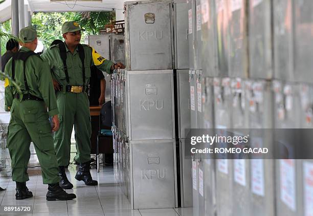 Ballot boxes containing results from polling centers are guarded at a government sub district election office in Jakarta on July 9, 2009 following...