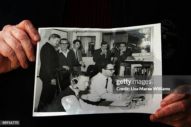 Retired Operations Supervisor John Saxon holds a photograph showing him as a young man in the control room at Honeysuckle Creek on July 20, 1969 -...