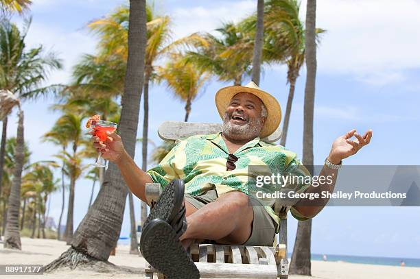 happy man relaxing with a drink at tropical beach - fort lauderdale imagens e fotografias de stock