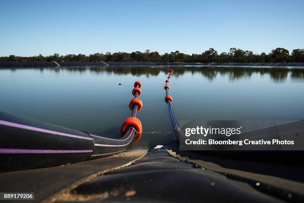 suction and discharge lines run into and out of a holding pond - oceana stock pictures, royalty-free photos & images