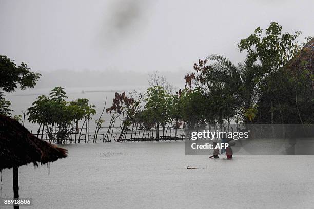 Displaced Bangladeshi villager makes her way through the water after collect drinking water in Koyra, on the outskirts of the south-western city of...