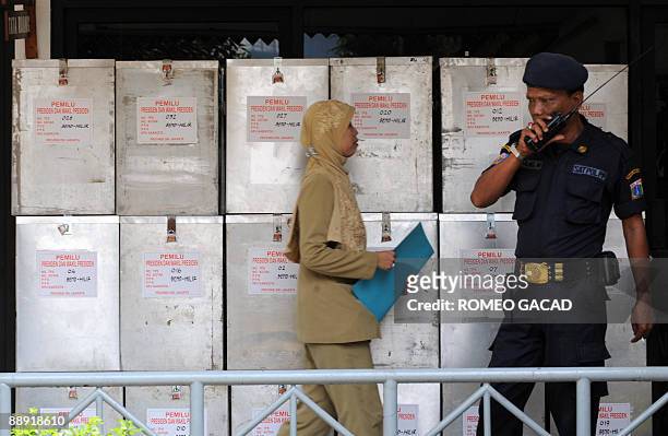 Ballot boxes containing results from polling centers are guarded at a government sub district election office in Jakarta on July 9, 2009 following...
