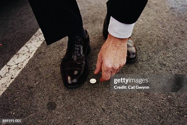 man picking up coin from street - lucky stock pictures, royalty-free photos & images