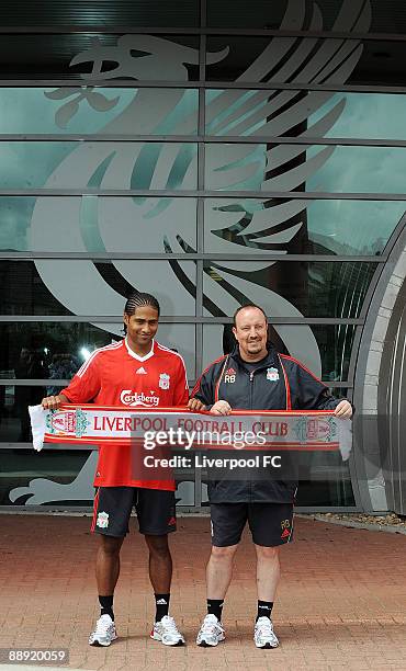 Liverpool's new signing Glen Johnson and Liverpool manager Rafael Benitez pose in front of Liverpool's crest symbol "The Liverbird" holding a...