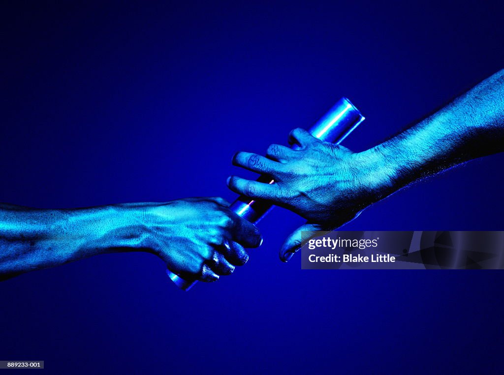 Hands passing baton (blue tone)