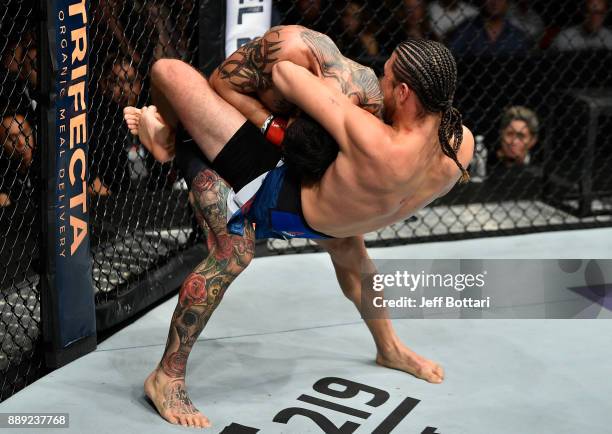 Brian Ortega attempts to submit Cub Swanson in their featherweight bout during the UFC Fight Night event inside Save Mart Center on December 9, 2017...