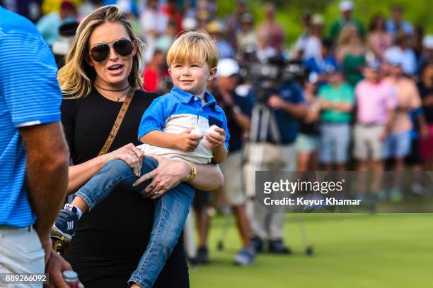Paulina Gretzky, wife of Dustin Johnson, carries their son Tatum after Dustin's 1-up victory during the championship match at the World Golf...