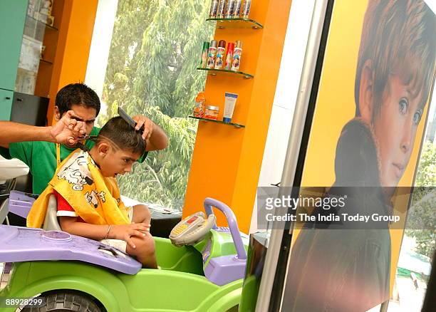 A kid is getting his hair cut by a hair stylist at the Water Melon... News  Photo - Getty Images
