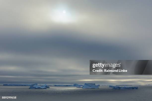 iceberg with low-hanging clouds and sun, antarctic sound, antarctic peninsula, antarctica - antarctic sound 個照片及圖片檔