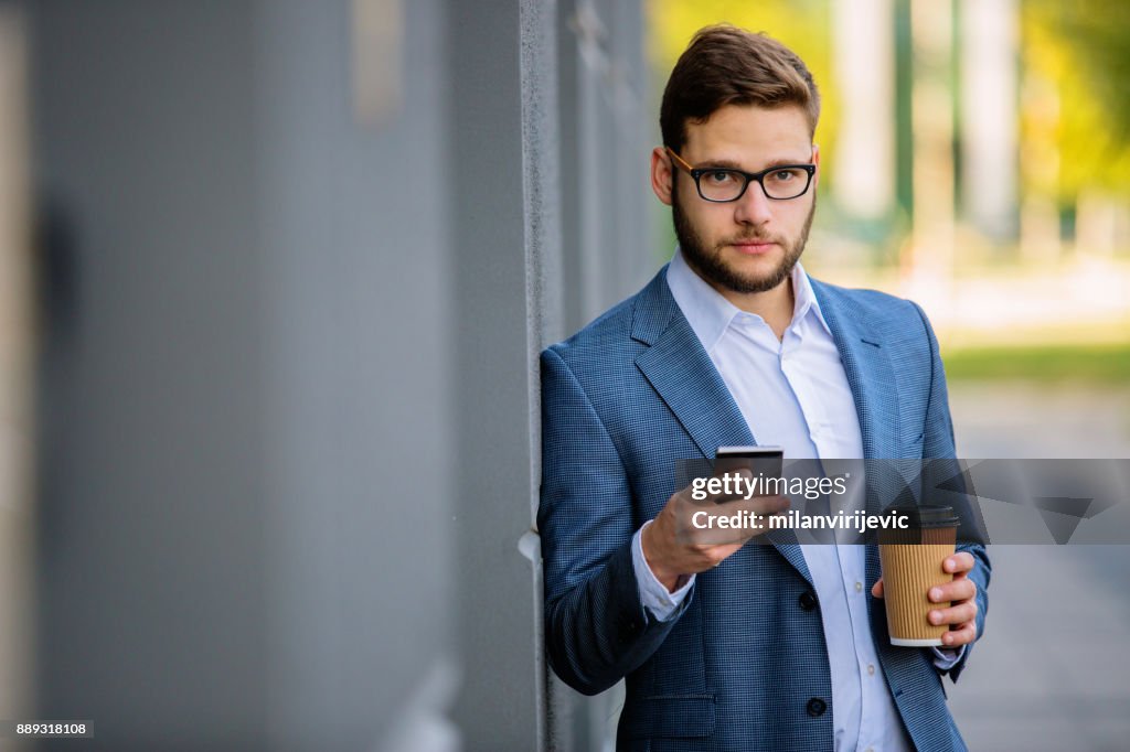 Young businessman having phone call outdoors