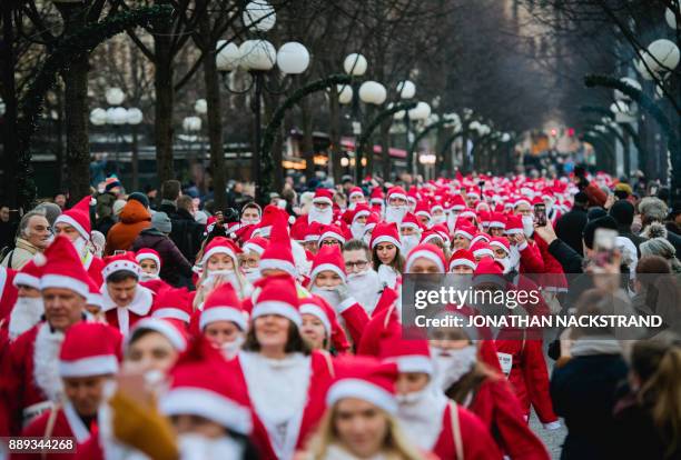 Charity runners dressed as Father Christmas participate in a 'Santa Run' charity fun run in Stockholm on December 10, 2017. Hundreds of participants...