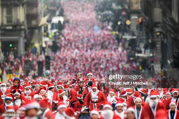 Over eight thousand members of the public take part in Glasgow's annual Santa dash make their way up St Vincent Street on December 10, 2017 in...