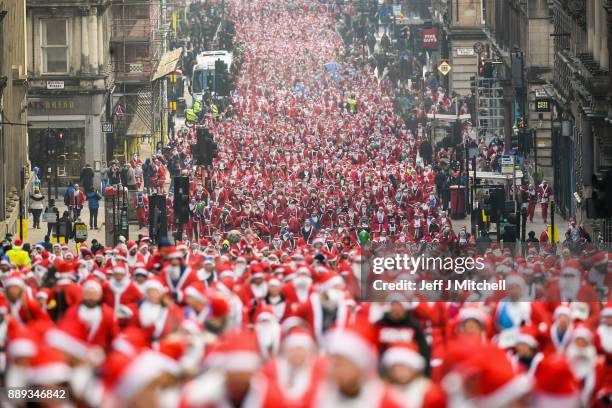 Over eight thousand members of the public take part in Glasgow's annual Santa dash make their way up St Vincent Street on December 10, 2017 in...