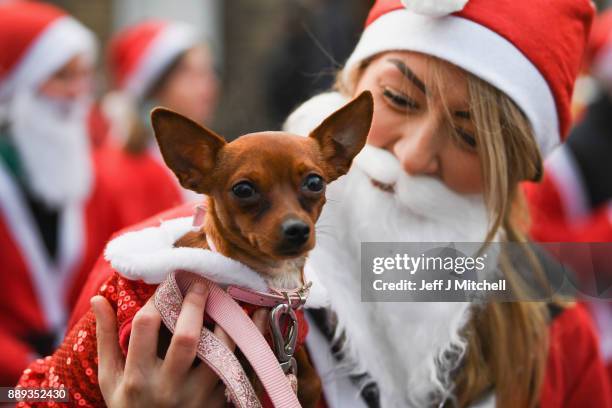 Over eight thousand members of the public take part in Glasgow's annual Santa dash make their way along St Vincent Street on December 10, 2017 in...