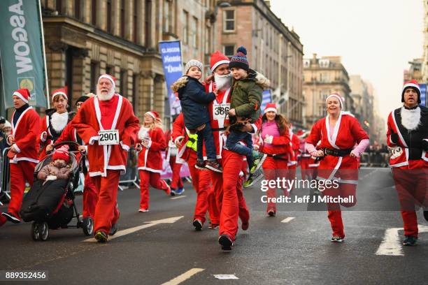 Over eight thousand members of the public take part in Glasgow's annual Santa dash make their way along St Vincent Street on December 10, 2017 in...