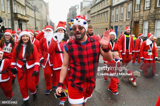 Over eight thousand members of the public take part in Glasgow's annual Santa dash make their way along St Vincent Street on December 10, 2017 in...