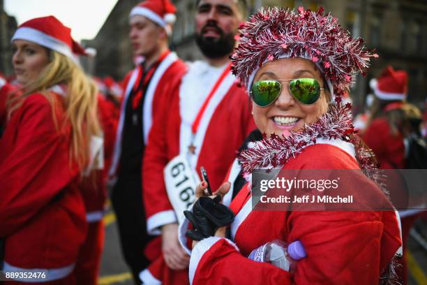 Over eight thousand members of the public take part in Glasgow's annual Santa dash make their way along St Vincent Street on December 10, 2017 in...