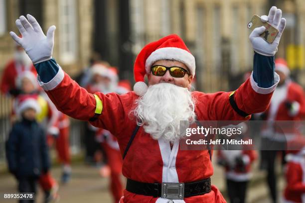 Over eight thousand members of the public take part in Glasgow's annual Santa dash make their way along St Vincent Street on December 10, 2017 in...