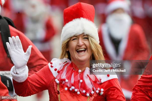 Over eight thousand members of the public take part in Glasgow's annual Santa dash make their way along St Vincent Street on December 10, 2017 in...