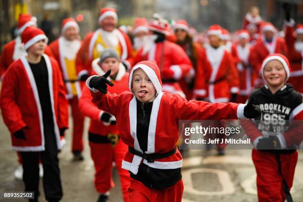 Over eight thousand members of the public take part in Glasgow's annual Santa dash make their way along St Vincent Street on December 10, 2017 in...