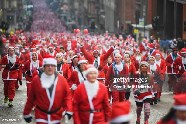 Over eight thousand members of the public take part in Glasgow's annual Santa dash make their way along St Vincent Street on December 10, 2017 in...