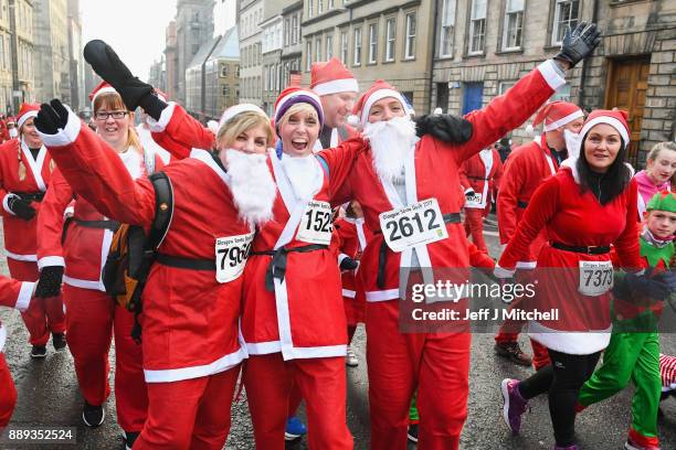 Over eight thousand members of the public take part in Glasgow's annual Santa dash make their way along St Vincent Street on December 10, 2017 in...