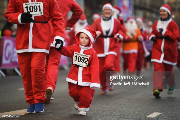 Over eight thousand members of the public take part in Glasgow's annual Santa dash make their way along St Vincent Street on December 10, 2017 in...