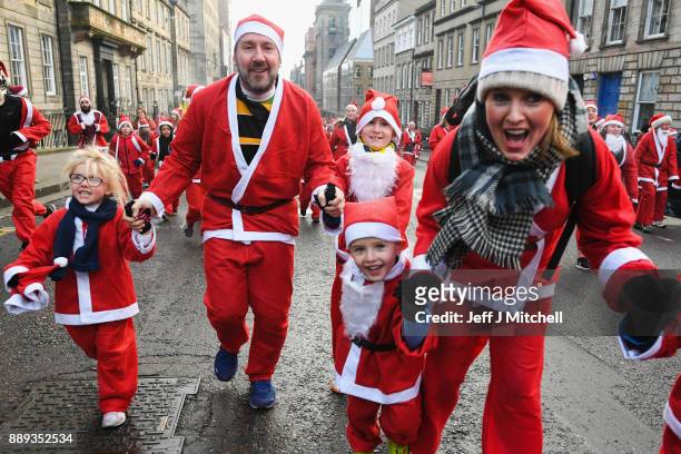 Over eight thousand members of the public take part in Glasgow's annual Santa dash make their way along St Vincent Street on December 10, 2017 in...