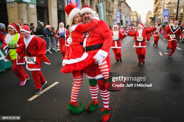 Over eight thousand members of the public take part in Glasgow's annual Santa dash make their way along St Vincent Street on December 10, 2017 in...