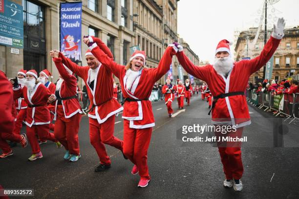 Over eight thousand members of the public take part in Glasgow's annual Santa dash make their way along St Vincent Street on December 10, 2017 in...