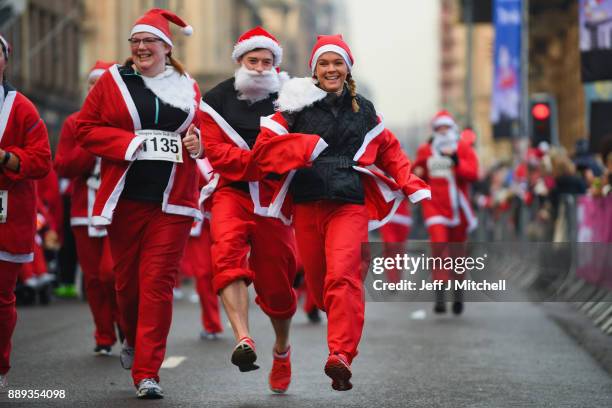 Over eight thousand members of the public take part in Glasgow's annual Santa dash make their way along St Vincent Street on December 10, 2017 in...