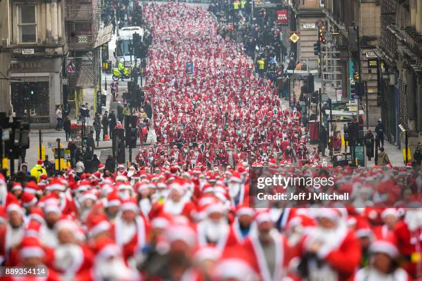 Over eight thousand members of the public take part in Glasgow's annual Santa dash make their way along St Vincent Street on December 10, 2017 in...