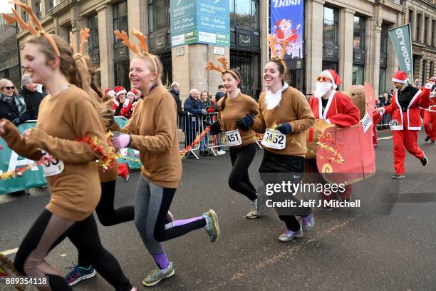 Over eight thousand members of the public take part in Glasgow's annual Santa dash make their way along St Vincent Street on December 10, 2017 in...