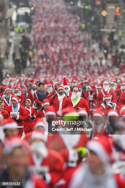 Over eight thousand members of the public take part in Glasgow's annual Santa dash make their way up St Vincent Street on December 10, 2017 in...