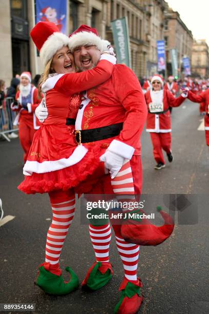 Over eight thousand members of the public take part in Glasgow's annual Santa dash make their way along St Vincent Street on December 10, 2017 in...