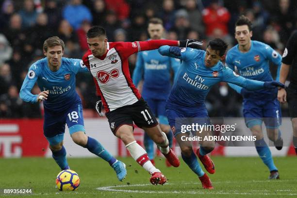 Southampton's Serbian midfielder Dusan Tadic vies with Arsenal's Spanish defender Nacho Monreal and Arsenal's Chilean striker Alexis Sanchez during...