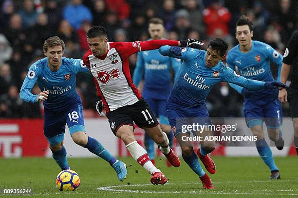 Southampton's Serbian midfielder Dusan Tadic vies with Arsenal's Spanish defender Nacho Monreal and Arsenal's Chilean striker Alexis Sanchez during...