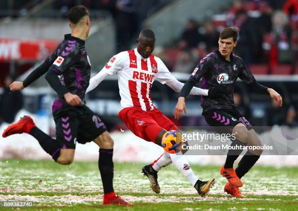 Sehrou Guirassy of FC Koeln is tackled by Robin Koch and Pascal Stenzel of SC Freiburg during the Bundesliga match between 1. FC Koeln and Sport-Club...