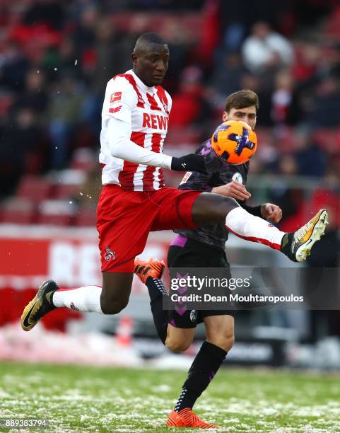 Sehrou Guirassy of FC Koeln is tackled by Pascal Stenzel of SC Freiburg during the Bundesliga match between 1. FC Koeln and Sport-Club Freiburg at...