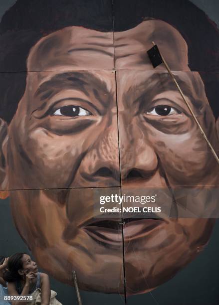 Woman looks at the effigy of Philippine President Rodrigo Duterte during a protest in Manila on December 10 as activists commemorate the...