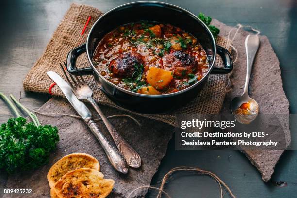 delicious stew dish, decorated with slices roasted potato and fresh parsley - plat mijoté photos et images de collection