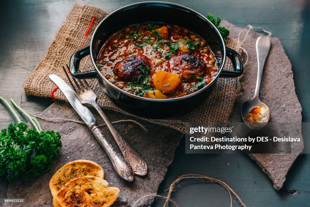 Delicious stew dish, decorated with slices roasted potato and fresh parsley